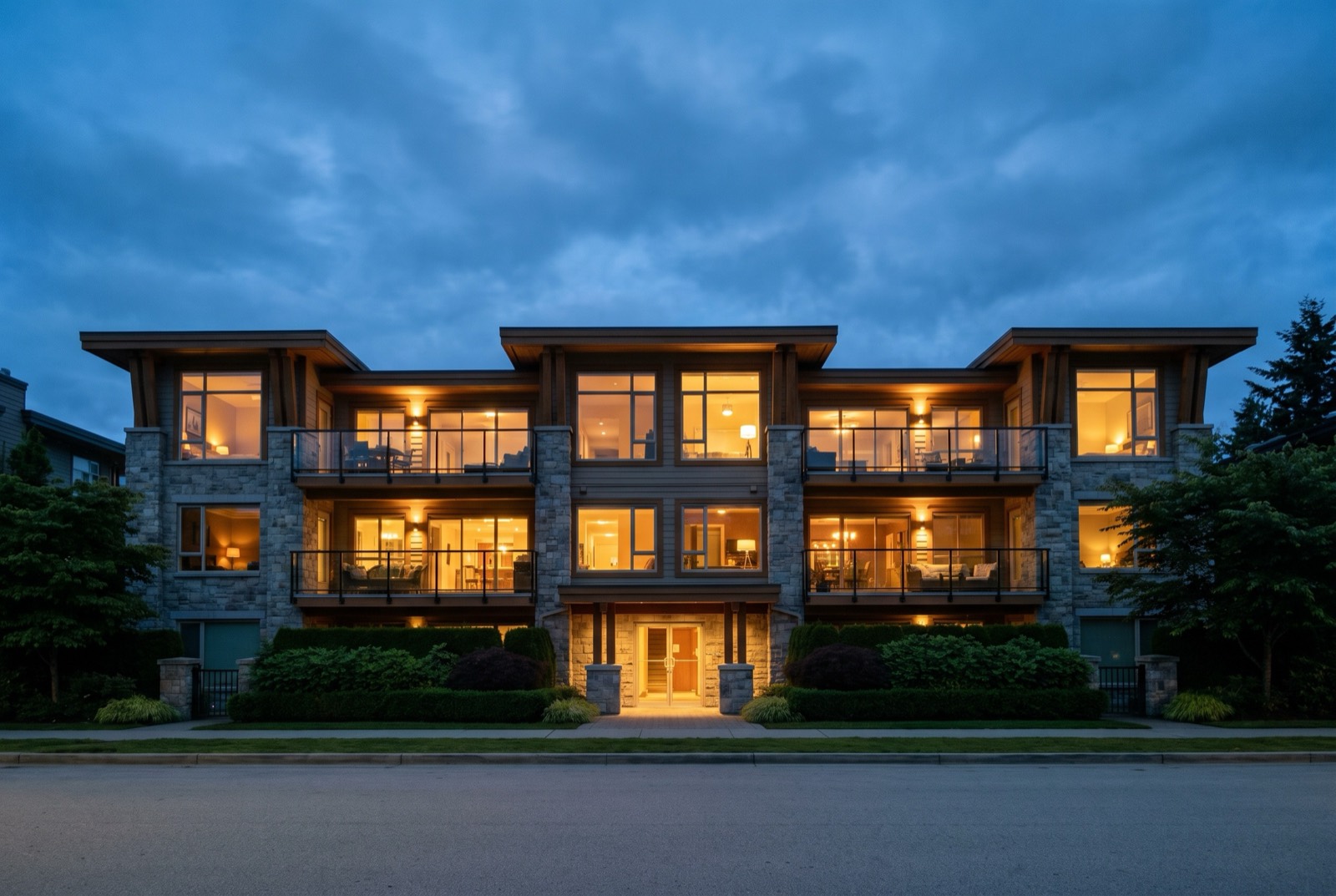 A three-storey building photographed at twilight with every window lit warm.